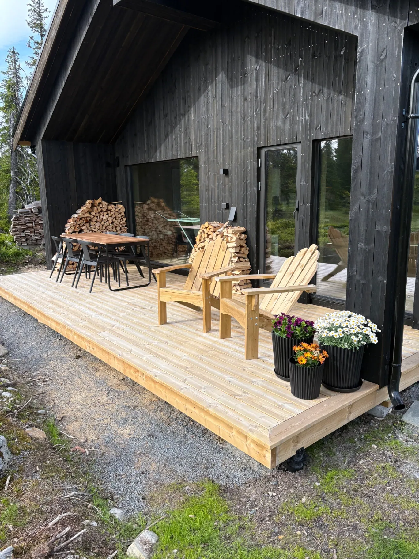 Terrasse med spisebord, stoler og vedstabler