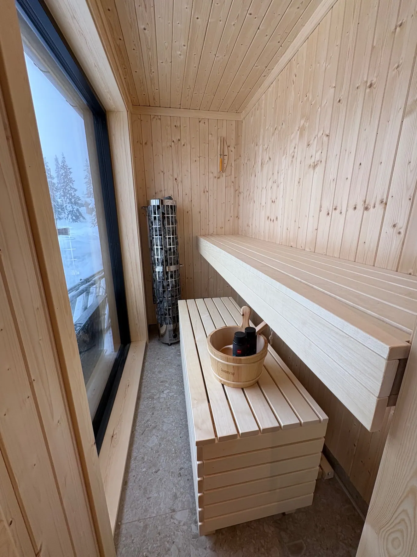 Badstue i lyst furu med vindu mot snøen
